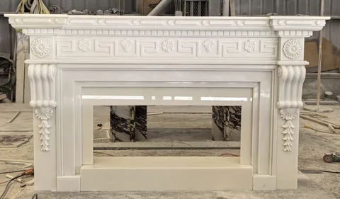White Volakas marble fireplace surround, with a plain surface and a reflective finish, in a workshop