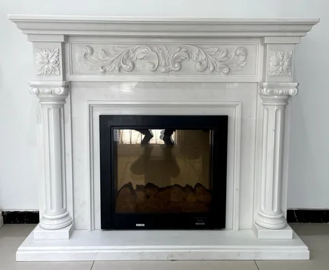 White Volakas marble fireplace surround, with fine veining and a reflective finish, in a showroom