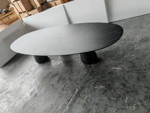 black stone dining table, with twin supporting bases and fine veining, in a workshop