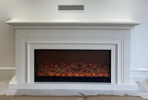 travertine fireplace surround, with stepped tiers and a plain surface, against a pale background