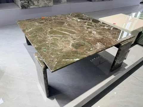 green stone coffee table, with twin supporting bases and bold veining, in a showroom