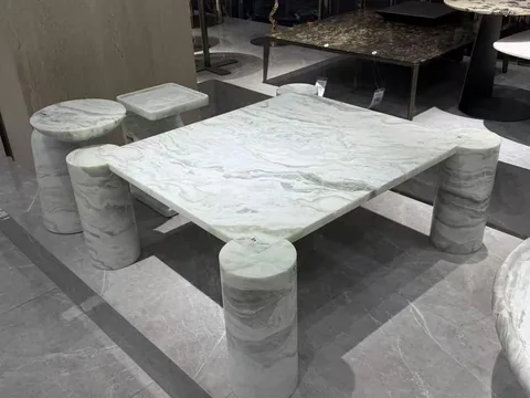 white stone coffee table, with fine veining and a reflective finish, in a showroom