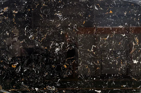 black engineered stone slab, with a single full slab and cloudy mottling, in a close surface view