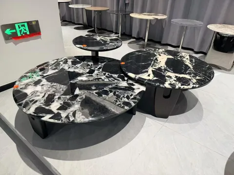 black stone coffee table, with angular breccia fragments and a reflective finish, in a showroom