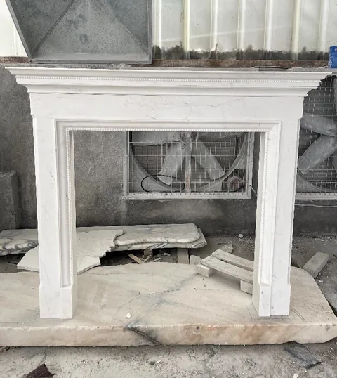 White Volakas marble fireplace surround, with fine veining, in a workshop