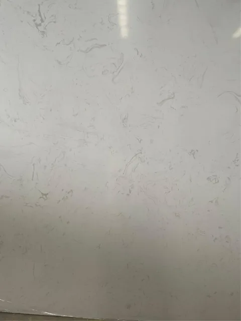 white engineered stone slab, with a single full slab and cloudy mottling, in a close surface view