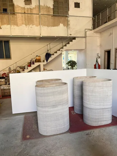 white stone landscape feature, with a stone planter and linear travertine grain, in a workshop