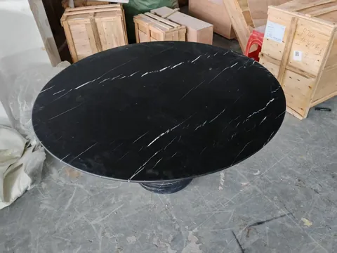 black stone dining table, with fine veining and a reflective finish, in a workshop