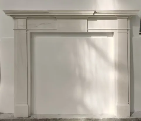 White Volakas marble fireplace surround, with fine veining, against a pale background