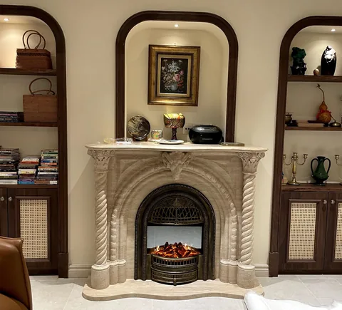 White Volakas marble fireplace surround, with an arched opening and linear travertine grain, in a furnished room