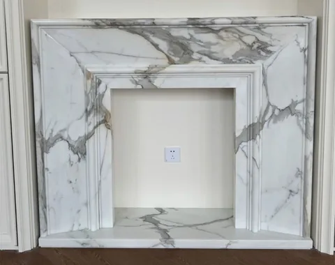 Arabescato Corchia marble fireplace surround, with bold veining, showing a single main form with an uncluttered setting