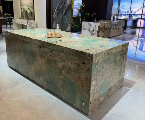 green stone countertop, with cloudy mottling and a reflective finish, in a showroom