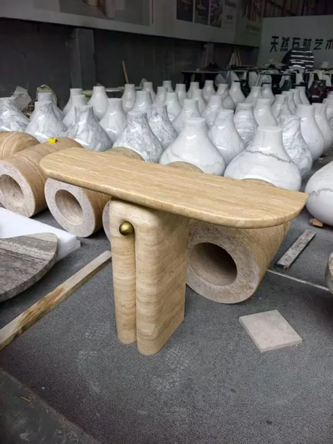 cream-beige stone coffee table, with linear travertine grain, in a workshop