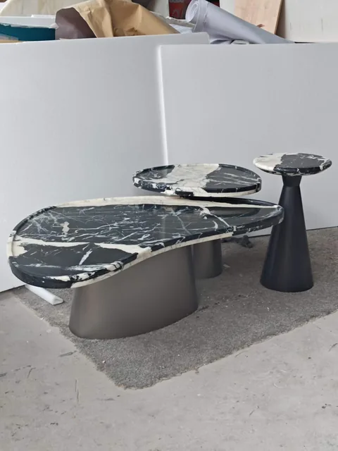 black stone coffee table, with bold veining and a reflective finish, in a workshop