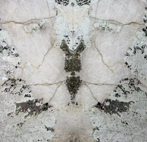 white stone slab, with a bookmatched slab pair and cloudy mottling, in a close surface view