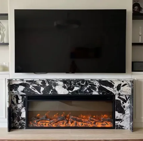 White Volakas marble fireplace surround, with bold veining and a reflective finish, in a furnished room