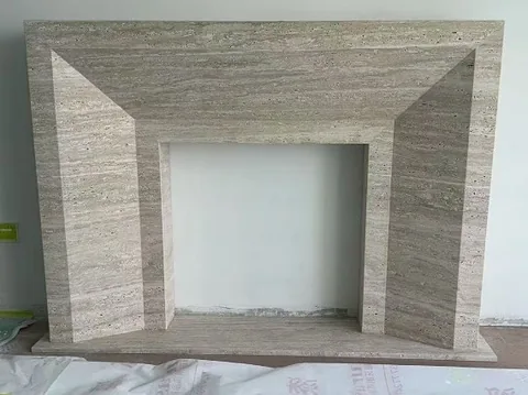 travertine fireplace surround, with linear travertine grain and a matte finish, in a workshop