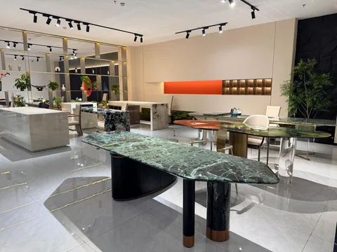 green stone dining table, with twin supporting bases and bold veining, in a showroom