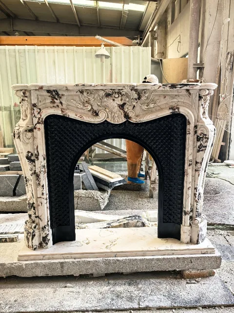 White Volakas marble fireplace surround, with an arched opening and bold veining, in a workshop