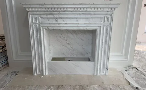 White Volakas marble fireplace surround, with fine veining, shown from a frontal view with broad sweeping markings