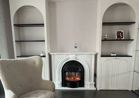 White Volakas marble fireplace surround, with plain surface, showing a single main form with room decor nearby