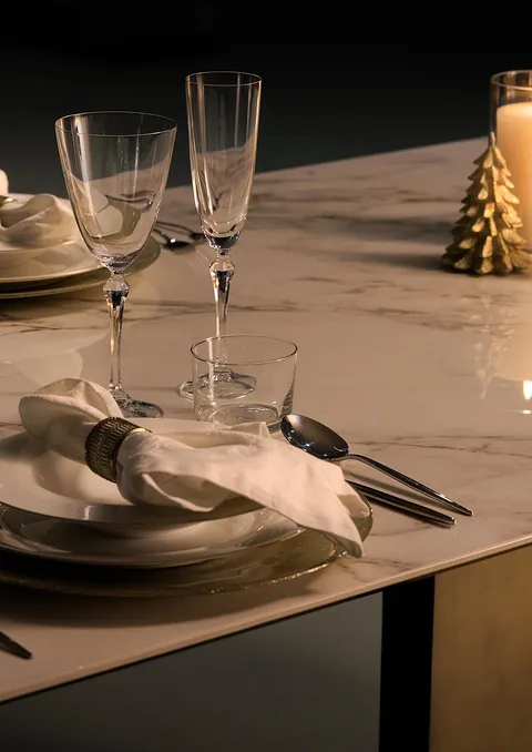 cream-beige stone dining table, with fine veining and a reflective finish, in a furnished room