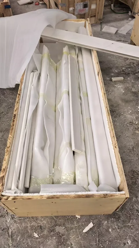 white stone fireplace surround, with visible white stone variation, in protective packing