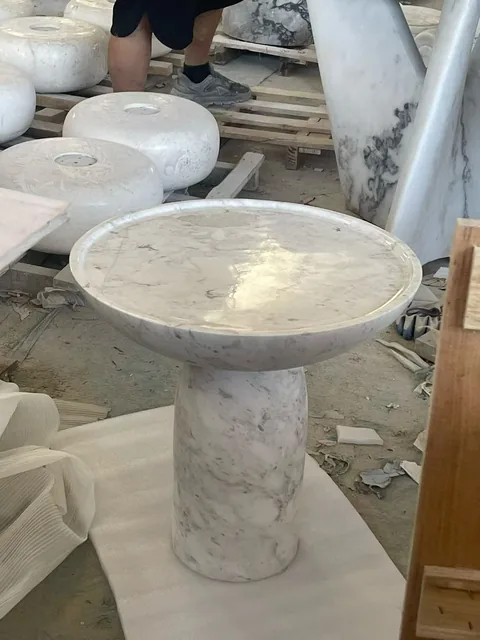 white stone sink, with a stone pedestal and fine veining, in a workshop
