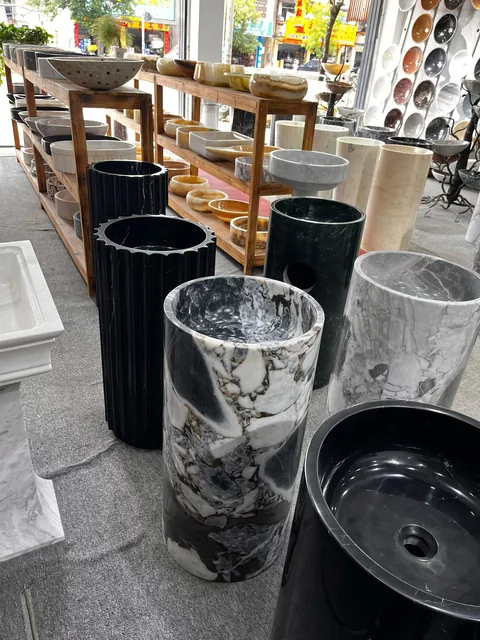 black stone sink, with bold veining and a reflective finish, in a showroom