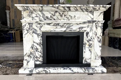 White Volakas marble fireplace surround, with bold veining and a reflective finish