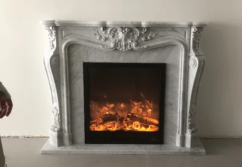 White Volakas marble fireplace surround, with carved scrollwork and fine veining, against a pale background