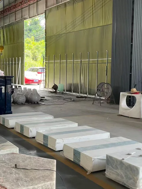 white stone slab, with a stack of related slabs and fine veining, in a workshop