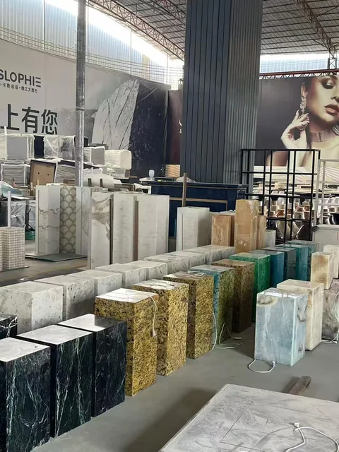 white stone slab, with a stack of related slabs and a speckled texture, near workshop equipment