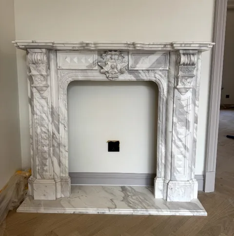 White Volakas marble fireplace surround, shown from a frontal view with single main form