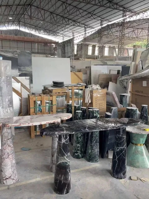 black stone dining table, with twin supporting bases and bold veining, in a workshop