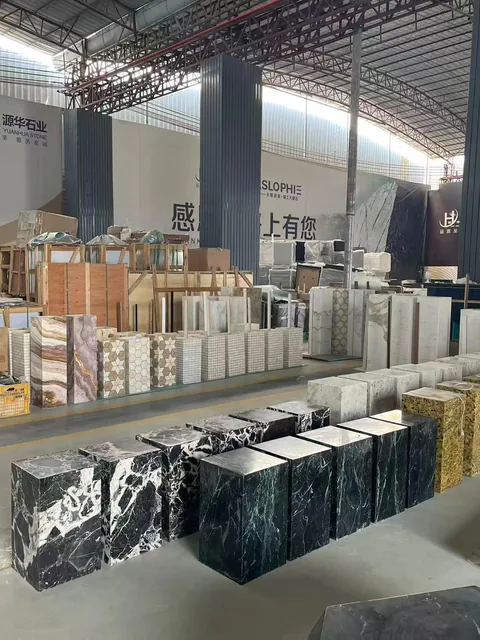 black stone slab, with a stack of related slabs and bold veining, near workshop equipment