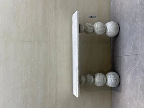 white stone console table, with twin supporting bases and cloudy mottling, in a showroom