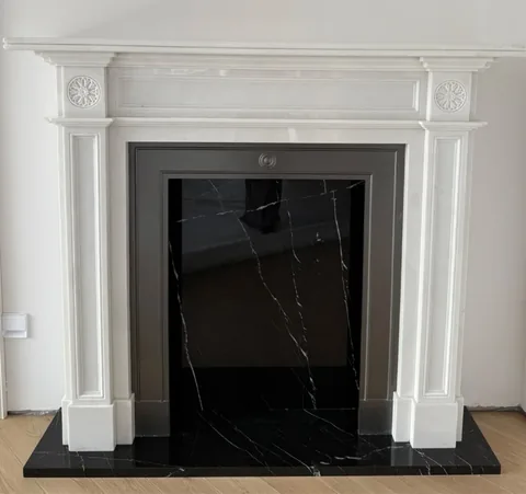 travertine fireplace surround, with fine veining and a reflective finish, against a pale background