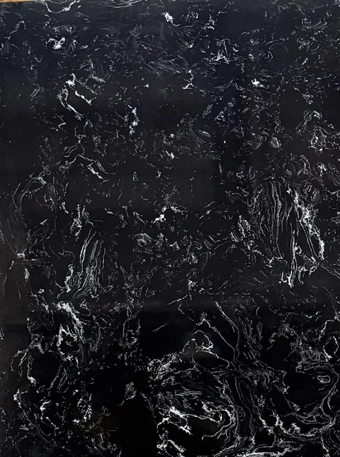 black engineered stone slab, with a single full slab and bold veining, in a close surface view