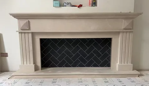 White Volakas marble fireplace surround, with fine veining and a soft satin finish, in a workshop