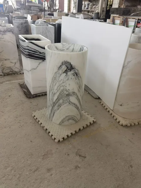 white stone landscape feature, with a stone planter and bold veining, in a workshop