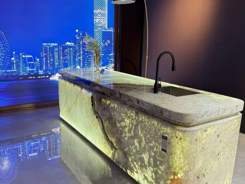 cream-beige stone countertop, with bold veining and a reflective finish, in a showroom