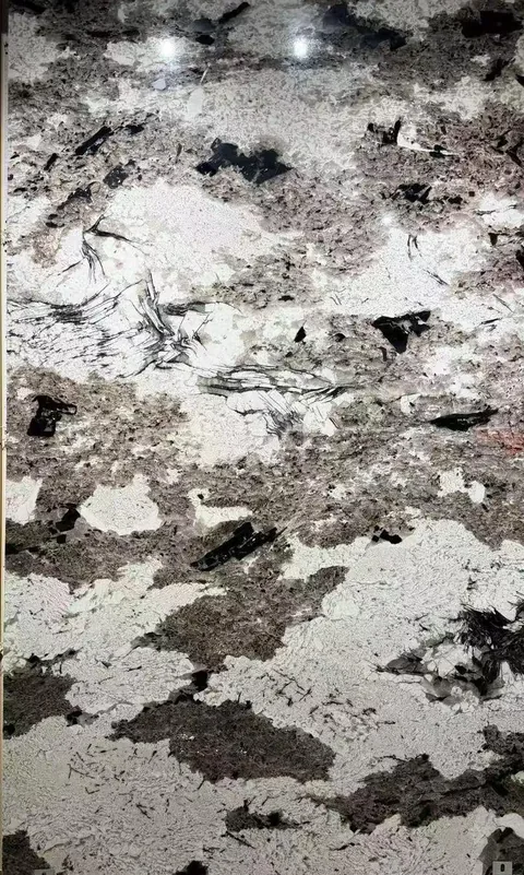 white stone slab, with cloudy mottling and a reflective finish, in a close surface view