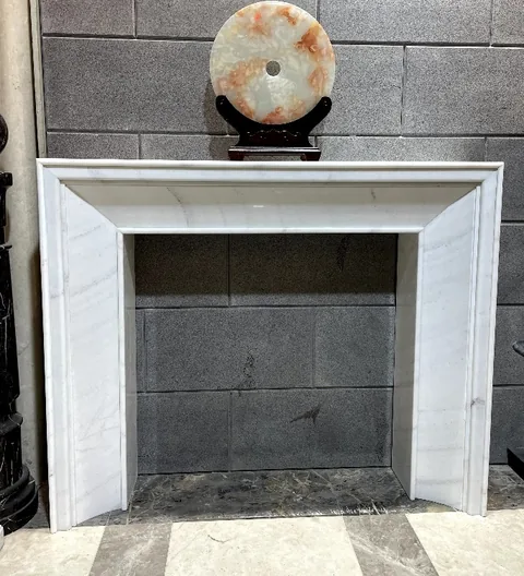 Arabescato Corchia marble fireplace surround, with fine veining and a reflective finish, in a showroom