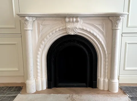 White Volakas marble fireplace surround, with fine veining, shown from a frontal view with single main form