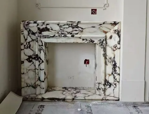 White Volakas marble fireplace surround, with bold veining, shown from a frontal view with broad sweeping markings