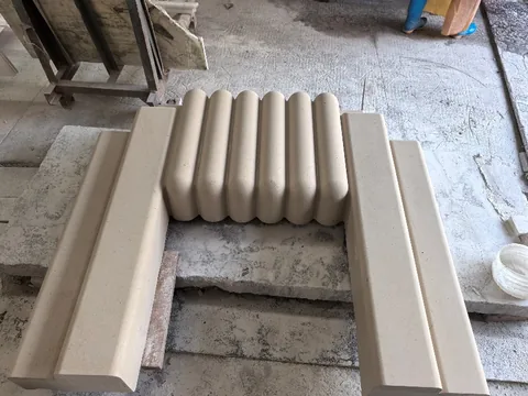 White Volakas marble fireplace surround, with a plain surface and a matte finish, in a workshop