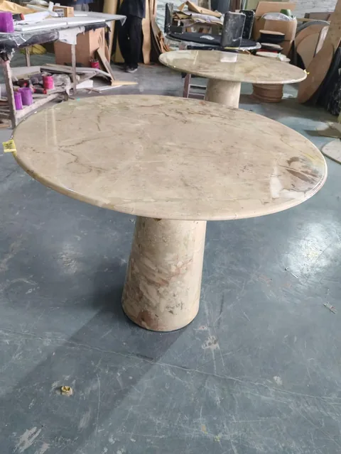 cream-beige stone dining table, shown from an angled view with broad sweeping markings