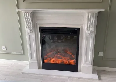 White Volakas marble fireplace surround, with a plain surface and a matte finish, in a furnished room