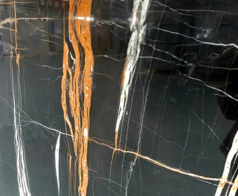 black stone slab, with bold veining and a reflective finish, in a close surface view